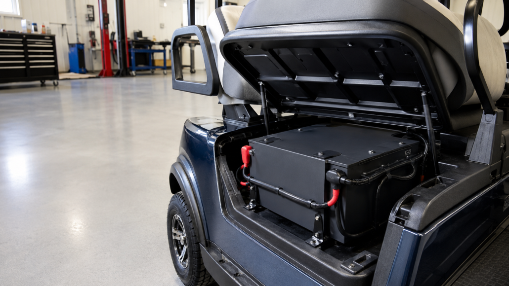 Technician inspecting the mounting and electrical connections of a lithium golf cart battery